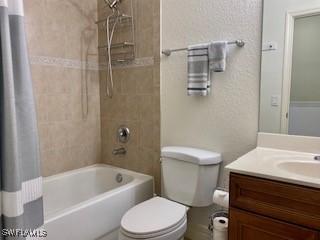 bathroom with toilet, shower / bath combo with shower curtain, and vanity