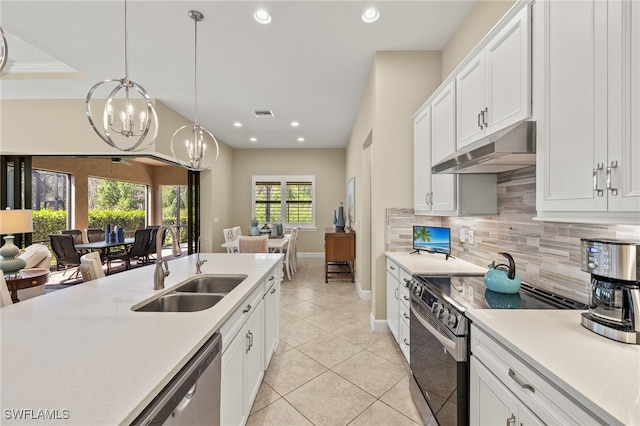 kitchen featuring stainless steel appliances, open floor plan, a sink, and under cabinet range hood