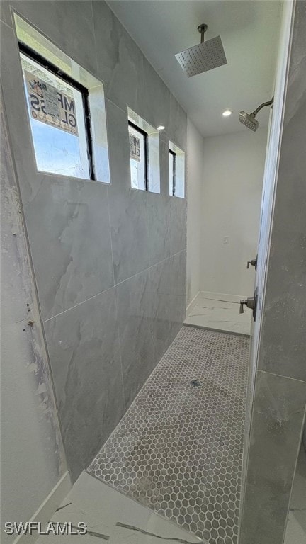 bathroom with tiled shower and tile patterned floors