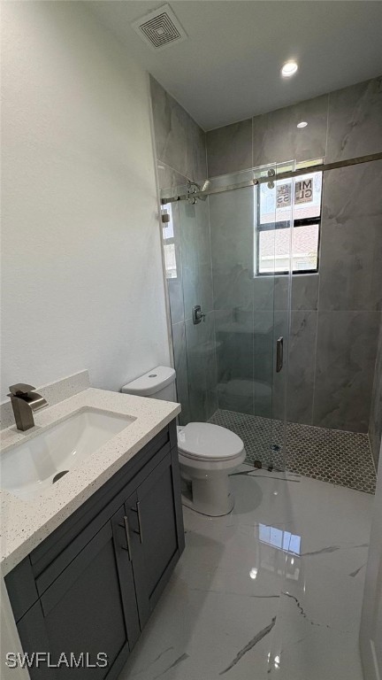 full bath featuring a stall shower, visible vents, toilet, marble finish floor, and vanity