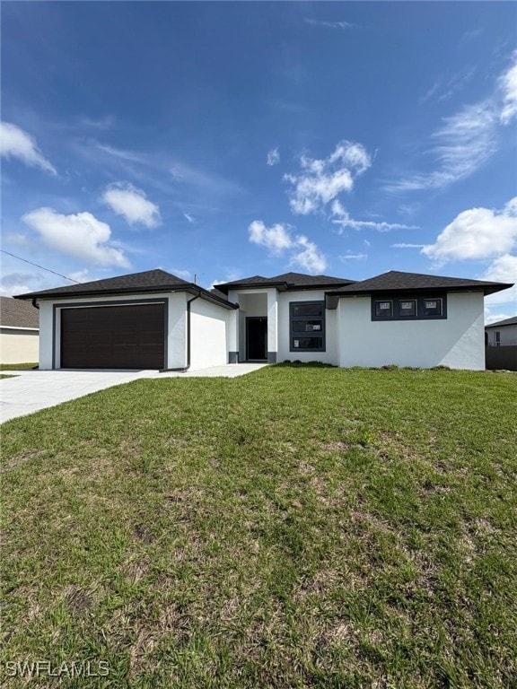 prairie-style home with a garage, driveway, a front lawn, and stucco siding