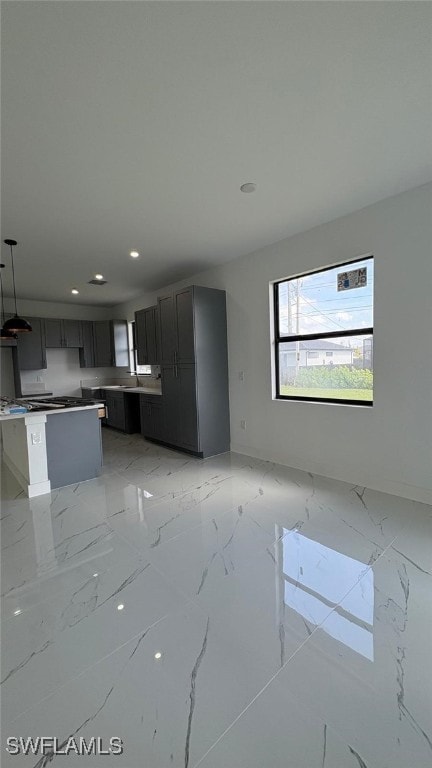 unfurnished living room with recessed lighting, marble finish floor, and a sink