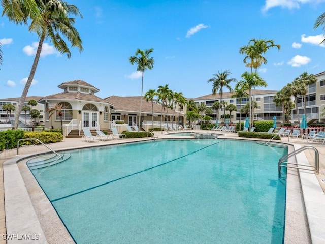 pool featuring a community hot tub, french doors, a patio area, and fence