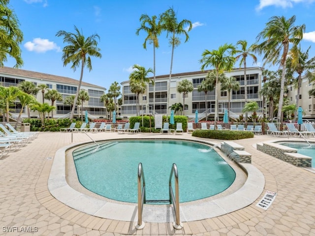 community pool with a patio area and a hot tub