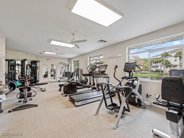 gym with carpet floors, visible vents, and a ceiling fan