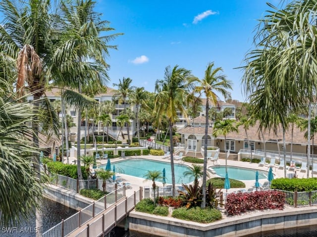 community pool with a patio area and fence