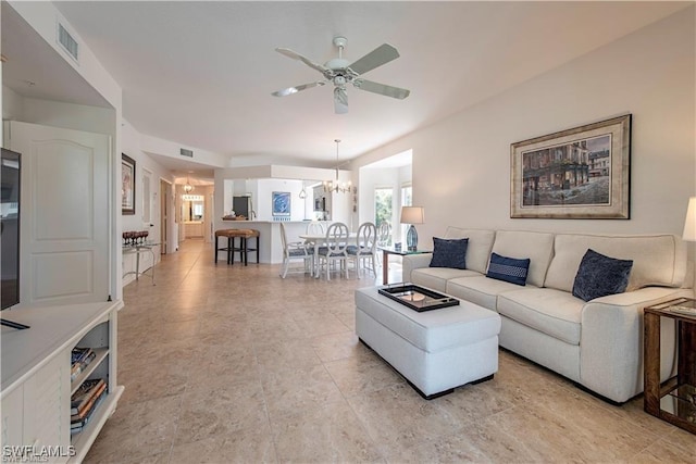 living area with ceiling fan with notable chandelier and visible vents