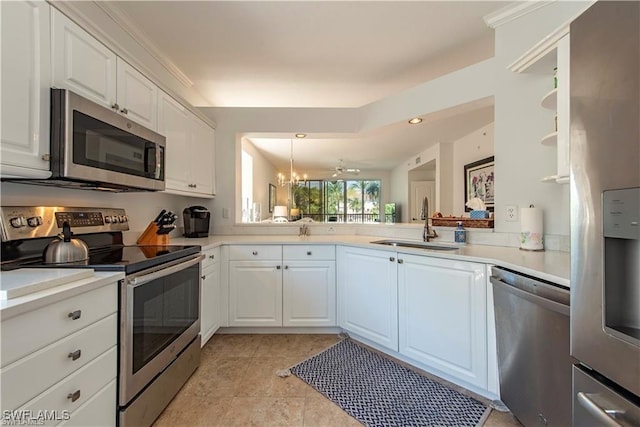 kitchen featuring appliances with stainless steel finishes, white cabinets, a sink, and light countertops