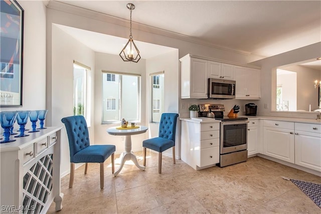 kitchen with white cabinetry, appliances with stainless steel finishes, light countertops, and a notable chandelier