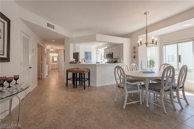 dining space featuring baseboards, visible vents, and an inviting chandelier