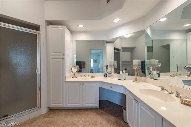 bathroom with a stall shower, a sink, recessed lighting, and double vanity