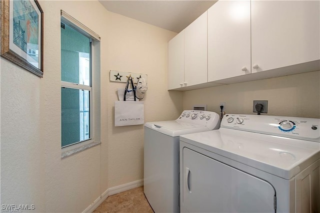 laundry area featuring washer and clothes dryer, cabinet space, and baseboards