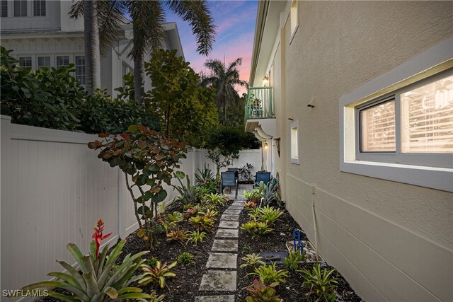 445 3rd Ave S Unit 102, Naples, FL 34102 - property exterior at dusk featuring stucco siding, a patio area, and a balcony