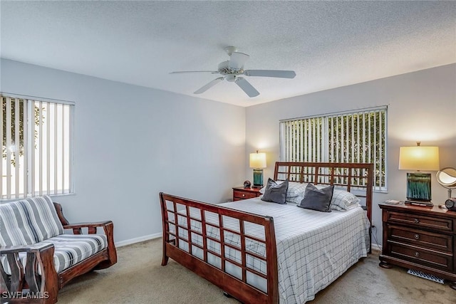 bedroom with baseboards, a textured ceiling, carpet, and a ceiling fan