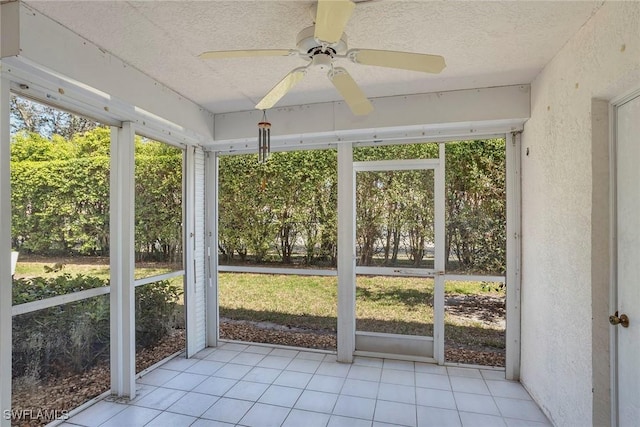 unfurnished sunroom featuring plenty of natural light and a ceiling fan