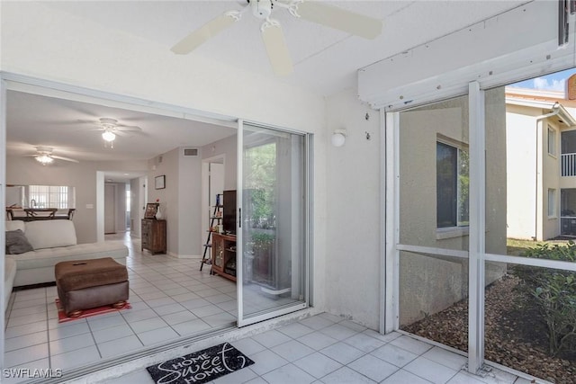 unfurnished sunroom featuring a ceiling fan