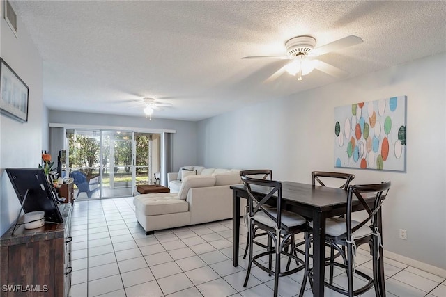 dining room featuring light tile patterned floors, visible vents, a textured ceiling, and ceiling fan