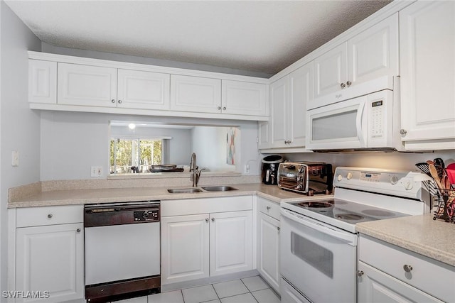 kitchen featuring a sink, white appliances, white cabinets, and light countertops