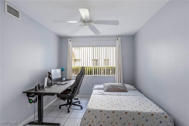 bedroom featuring light tile patterned floors, visible vents, baseboards, and a ceiling fan