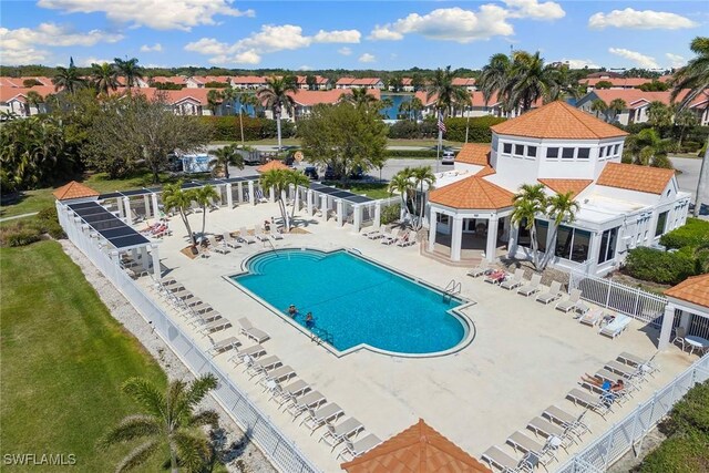 pool with a residential view, a patio, and fence