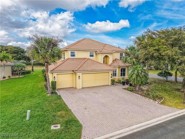 mediterranean / spanish-style home with a garage, a tiled roof, decorative driveway, stucco siding, and a front yard