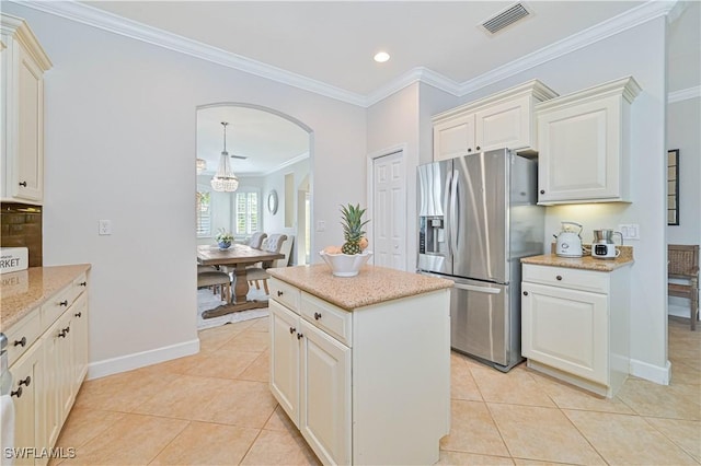 kitchen featuring light tile patterned floors, visible vents, stainless steel refrigerator with ice dispenser, and crown molding