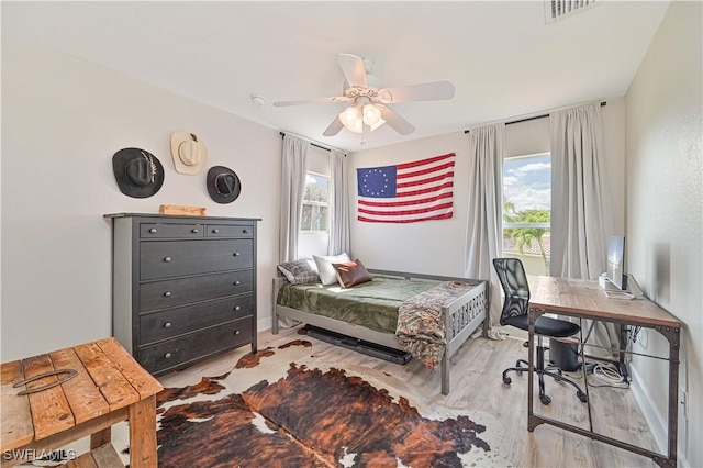 bedroom with light wood-style floors, multiple windows, visible vents, and a ceiling fan
