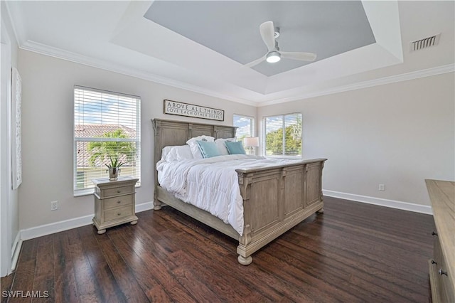 bedroom featuring a tray ceiling, visible vents, and multiple windows