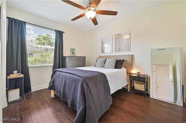 bedroom with dark wood-style floors, a ceiling fan, and baseboards