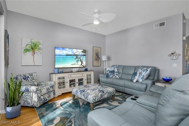 living room with wood finished floors, visible vents, and ceiling fan