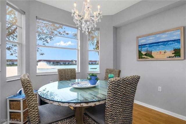 dining space featuring baseboards, wood finished floors, and a chandelier