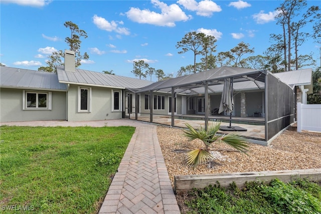 rear view of house featuring an outdoor pool, a lanai, a patio, and stucco siding