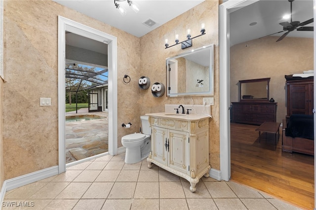 bathroom with baseboards, toilet, ceiling fan, tile patterned flooring, and vanity