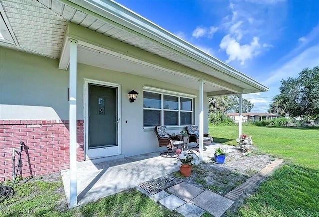 property entrance featuring stucco siding and a yard