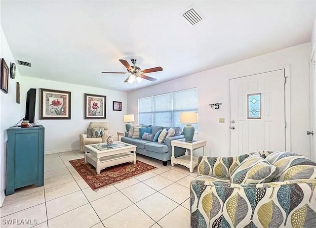 living area with light tile patterned floors, ceiling fan, visible vents, and baseboards