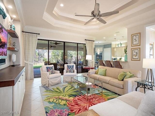 living area featuring ornamental molding, a ceiling fan, a raised ceiling, and light tile patterned floors