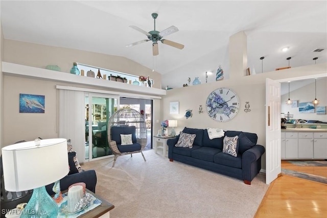 living area with lofted ceiling, visible vents, a ceiling fan, and light colored carpet