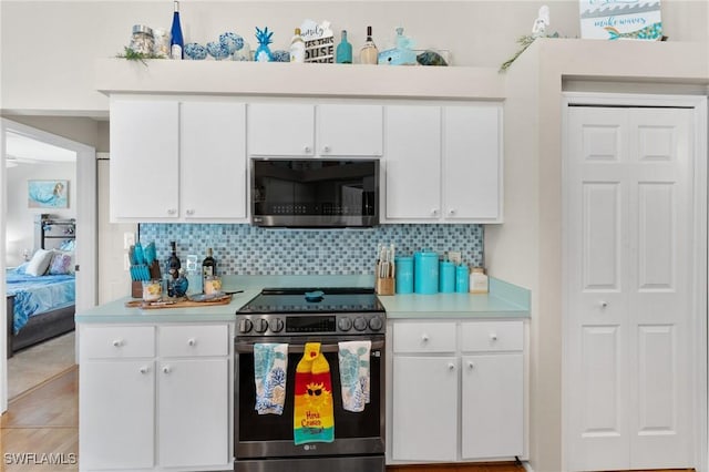 kitchen featuring light countertops, appliances with stainless steel finishes, backsplash, and white cabinets