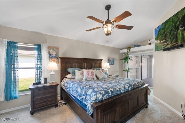 bedroom with lofted ceiling, ceiling fan, light colored carpet, and baseboards