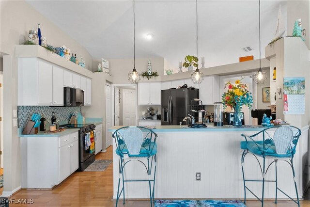 kitchen featuring white cabinets, black range with electric stovetop, a peninsula, and stainless steel fridge with ice dispenser