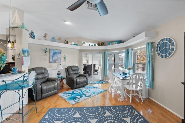 living area with lofted ceiling, baseboards, a ceiling fan, and wood finished floors