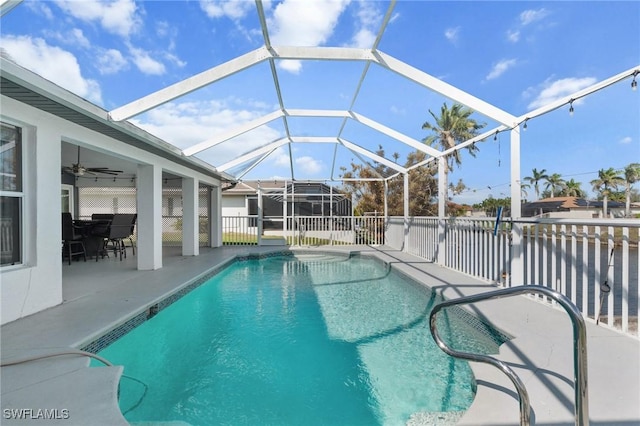 view of swimming pool featuring a patio area, ceiling fan, glass enclosure, and a fenced in pool