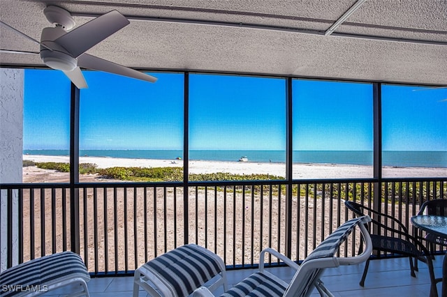 unfurnished sunroom with a beach view and a water view