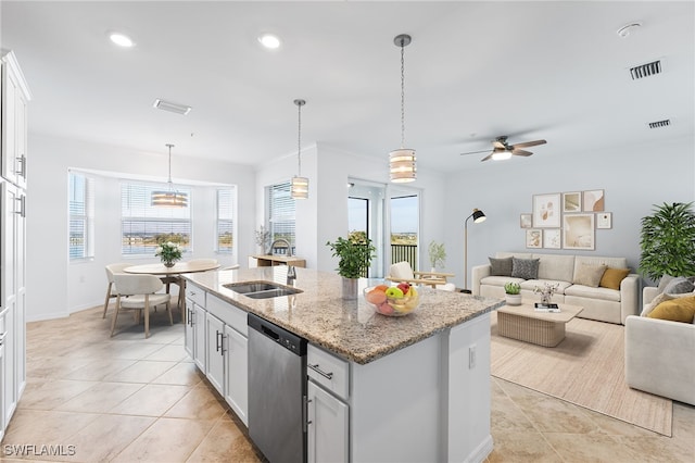 kitchen with dishwasher, a center island with sink, visible vents, and a sink