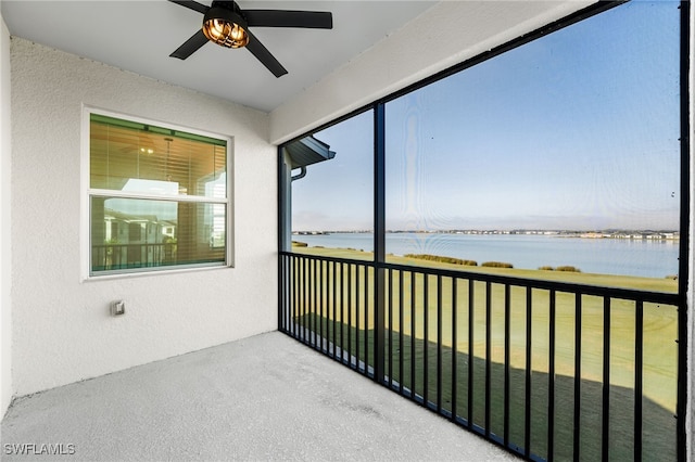 unfurnished sunroom with a water view and ceiling fan