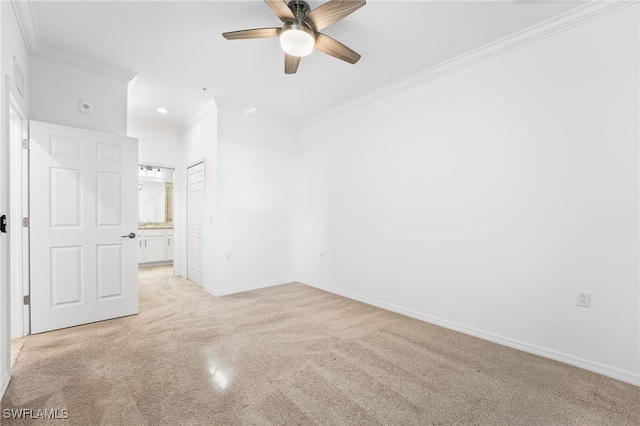 unfurnished bedroom featuring baseboards, ensuite bath, ceiling fan, crown molding, and light colored carpet