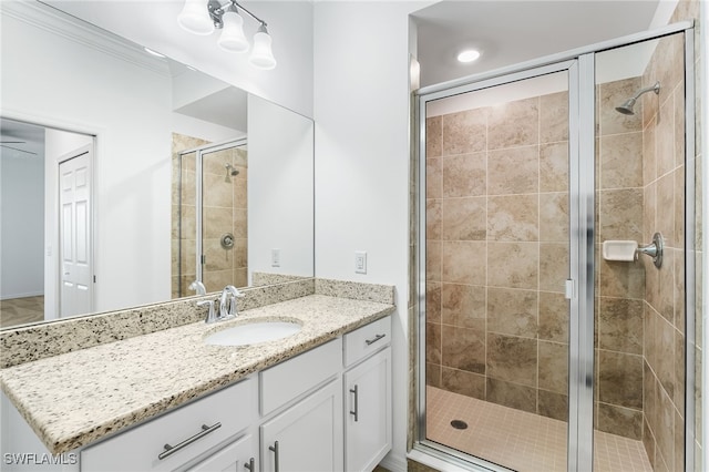 bathroom with a shower stall, vanity, crown molding, and a ceiling fan