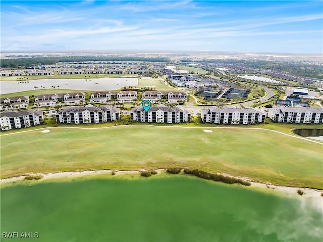 aerial view with golf course view and a water view