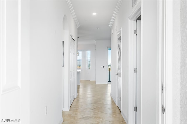 hallway featuring light tile patterned floors, visible vents, and ornamental molding