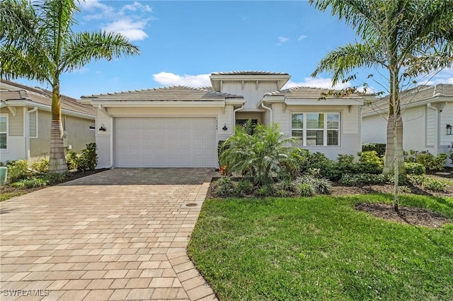 view of front of home featuring a garage, a front lawn, decorative driveway, and a tile roof